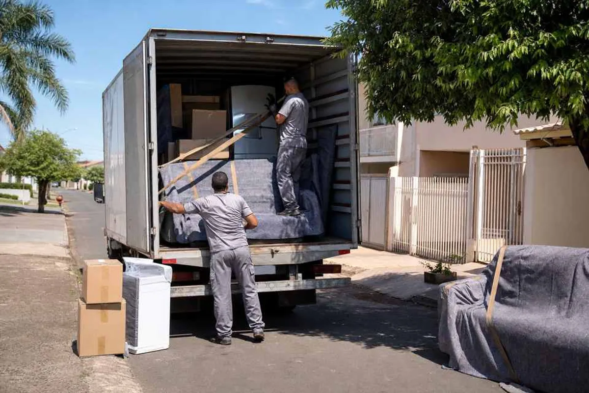 Equipe de carreto organizando mudança com caminhão baú em Dourados